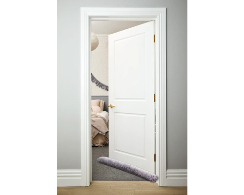Weiß lackierte Tür mit Zugluftstopper im Schlafzimmer