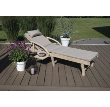 Holzliege mit Auflage, Seitentisch und Dekoration im Garten