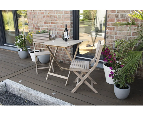 Gartenszene mit Holztisch, Stühlen, Weinflasche und Gläsern auf einer Terrasse