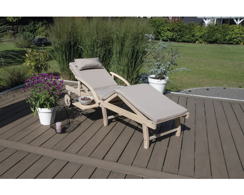 Holzliege mit Auflage und Beistelltisch im Garten.
