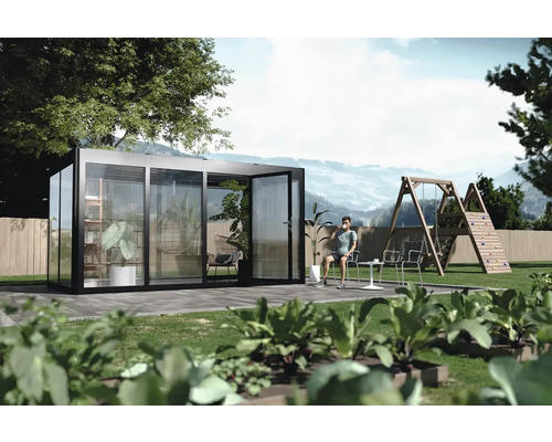 Freistehendes Gewächshaus mit Pflanzen und einem Mann, der im Garten sitzt.