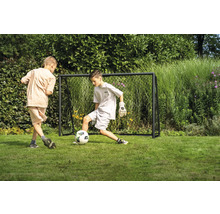 Zwei Jungen spielen Fußball vor einem Fußballtor im Garten.
