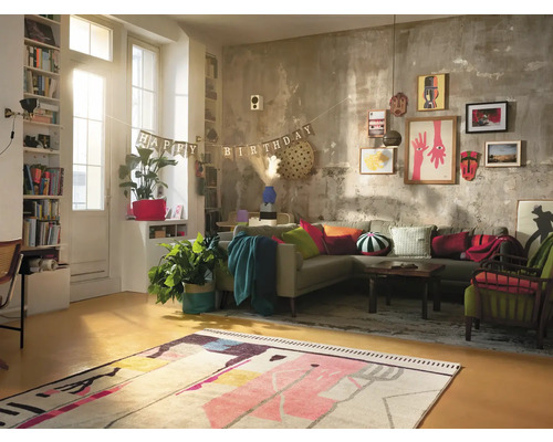 Wohnzimmer mit Ecksofa, Teppich, Dekoration und Geburtstagsgirlande.