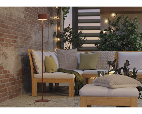 Szene mit einer Stehlampe neben einer Loungegarnitur auf einer Terrasse