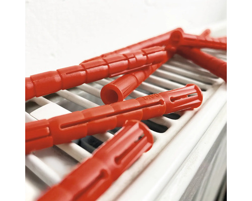 Mehrere rote Dübel auf einem Heizkörper