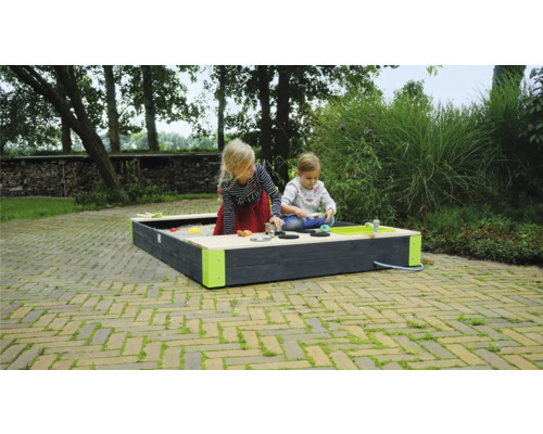 Zwei Kinder spielen in einem Sandkasten mit Spielküche im Garten.