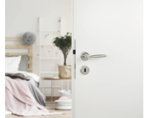 Geöffnete weiße Tür mit silberfarbener Türklinke in Schlafzimmer