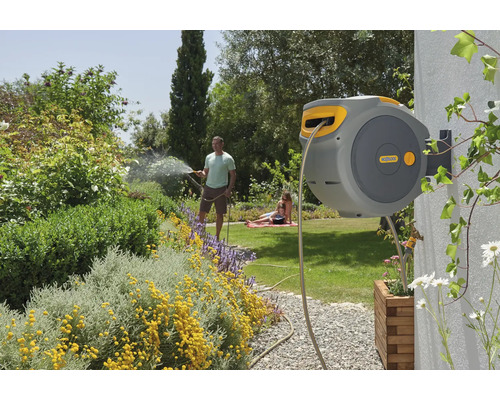 Wand-Schlauchbox im Garten mit Familie beim Bewässern der Pflanzen