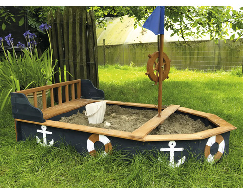 Sandkasten in Bootsform mit Anker und Rettungsring im Garten