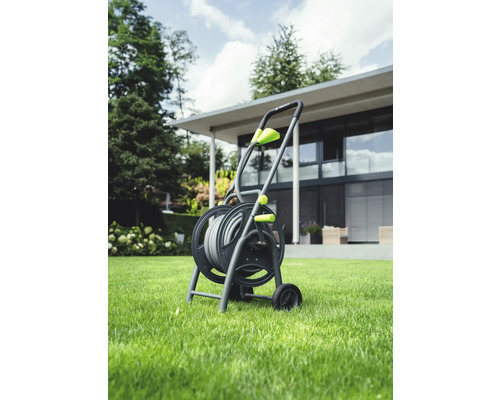 Gartenschlauchwagen mit Gartenschlauch auf Rasen vor einem Haus