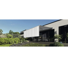 Terrasse mit Markise und Gartenmöbeln vor einem modernen Haus