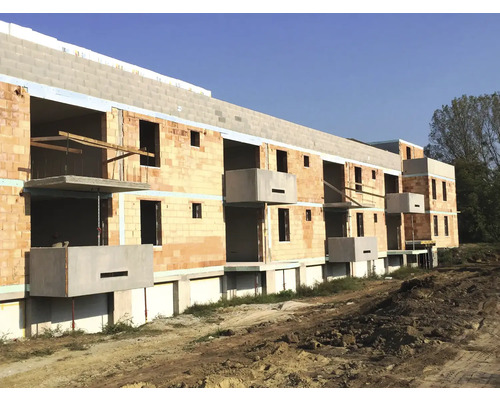 Rohbau eines Mehrfamilienhauses mit Mauerwerk und Betonbalkonen