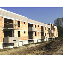 Rohbau eines Mehrfamilienhauses mit Ziegelmauerwerk und Betonbalkonen