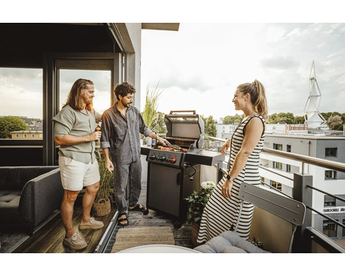 Personen grillen auf dem Balkon mit einem Gasgrill.