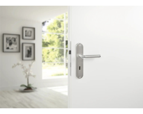 Geöffnete weiße Tür mit silberfarbener Türklinke im modernen Stil