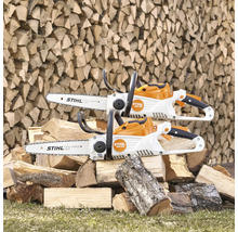 Zwei Akku-Kettensägen von Stihl auf einem Stapel Holz