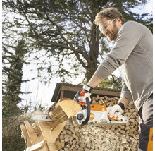 Mann sägt Holz mit einer Akku-Kettensäge von Stihl im Garten.