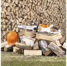 Akku-Kettensäge mit Sicherheitsausrüstung auf Holzstapel