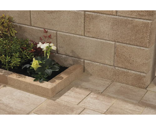 Gartenmauer aus Betonsteinen mit Blumenkasten und Pflanzen