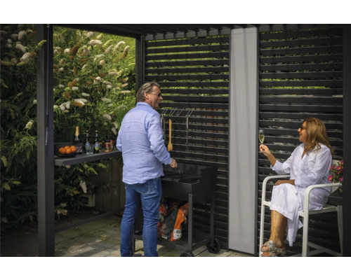 Szene einer Gartenparty mit Grill unter einer Terrassenüberdachung mit Lamellenwand
