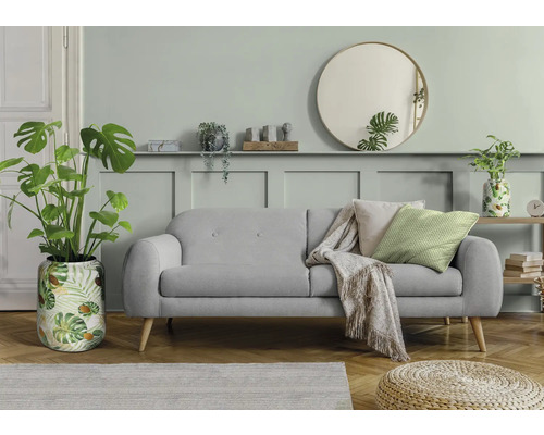 Wohnzimmer mit grauem Sofa, Zimmerpflanzen, rundem Spiegel und Holzboden