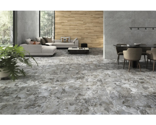 Innenraum mit Bodenfliesen in Steinoptik, Sofa, Esstisch und Pflanze