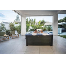 Außenbereich mit Whirlpool und zwei Personen, die anstoßen