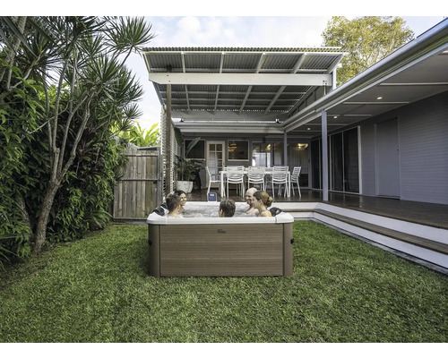 Szene mit einem Whirlpool im Garten, in dem sich mehrere Personen entspannen.