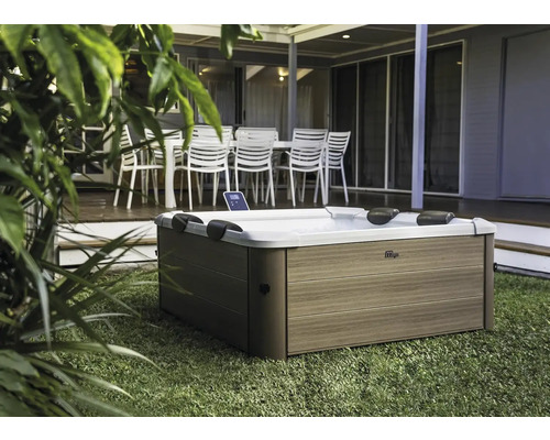 Outdoor Whirlpool auf Rasen vor Terrasse mit Gartenmöbeln