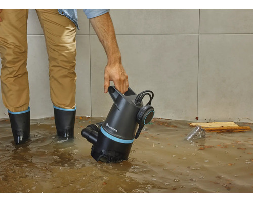 Mann mit Gardena Schmutzwasserpumpe in überflutetem Raum.