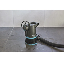 Gartenpumpe mit Schlauch auf Fliesenboden