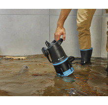 Eine Person benutzt eine Gardena Schmutzwasserpumpe in einem überfluteten Raum.