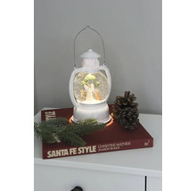 Dekorative Laterne mit Schneekugel, Engel und Tannenbaum auf einem Nachttisch