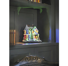 Dekorative beleuchtete Weihnachtshaus-Szene auf einem Regal