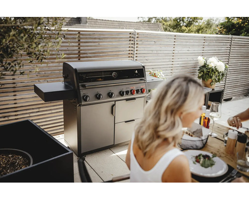 Gasgrill mit Seitenablage und Unterschrank auf einer Terrasse