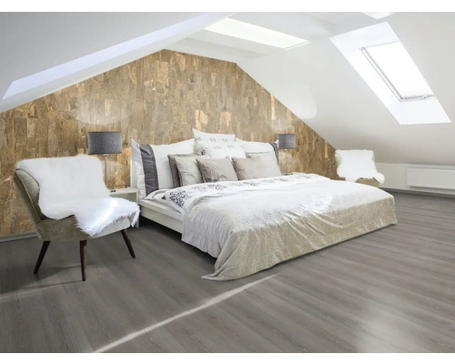 Schlafzimmer im Dachgeschoss mit Doppelbett, Stuhl und Korktapete