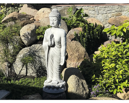 Buddha Statue im Garten zwischen Steinen und Pflanzen