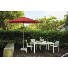 Gartenszene mit rotem Sonnenschirm, Gartentisch und Stühlen auf einer Terrasse
