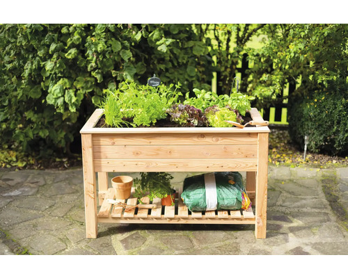 Hochbeet aus Holz mit Kräutern und Gartenzubehör