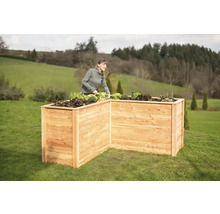 Hochbeet aus Holz im Garten mit Frau bei der Gartenarbeit