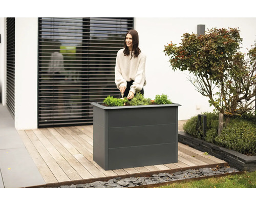 Hochbeet aus Metall mit Frau beim Bepflanzen im Garten