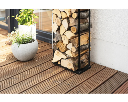 Holzstapelregal aus Metall mit Brennholz auf einer Holzterrasse