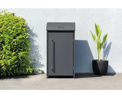 Freistehender Paketbriefkasten neben Pflanze und Busch