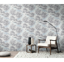 Ein Zimmer mit Wolkenmustertapete, einem Sessel, einer Stehlampe und einem Beistelltisch.