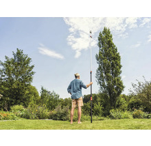 Mann benutzt eine Teleskopstiel-Astsäge im Garten zur Baumpflege