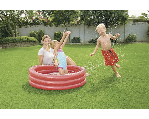 Familie mit aufblasbarem Planschbecken im Garten