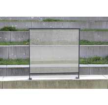 Windschutz aus Glas mit Metallrahmen vor einer Betontreppe