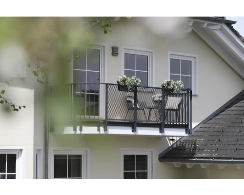 Außenansicht eines Hauses mit Balkon, Balkonmöbeln und Blumenkästen