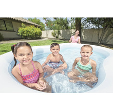 Kinder spielen in einem aufblasbaren Pool im Garten.