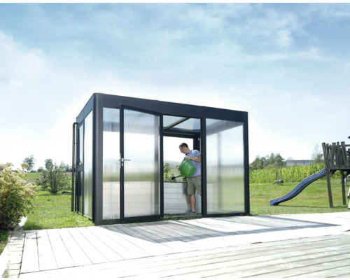 Gewächshaus SunGarden Select 3.2 Polycarbonat 10 mm 338 x 233 cm anthrazit Gewächshaus mit Person, die eine Pflanze gießt, im Garten